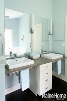 a bathroom with two sinks and mirrors in it