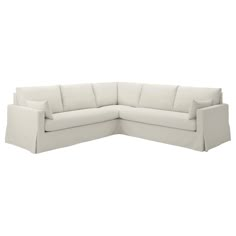 a white sectional couch with pillows on the top and bottom corner, facing away from the camera