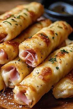 ham and cheese spring rolls on a cutting board