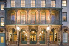 an old building with many windows and balconies on the top floor is lit up at night