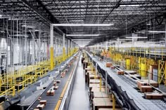 the inside of a large warehouse with lots of yellow and black items on it's racks