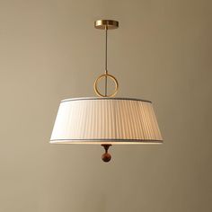 a lamp hanging from the ceiling with a white shade