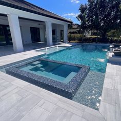 an empty swimming pool in front of a house