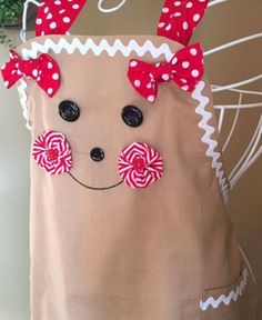 a brown apron with red bows and candy canes on it's side, decorated like a reindeer