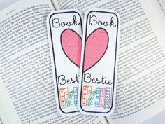 two bookmarks with the words best and best written on them in front of an open book