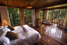 a bedroom with wooden floors and large windows