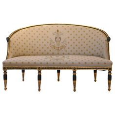 an ornately decorated couch with black legs and gold trimmings on the back