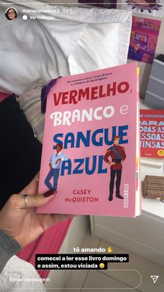 a person holding up a pink book in their hand with spanish writing on the cover