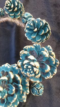 some blue and white pine cones on a black cloth