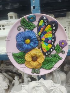 a ceramic plate with flowers and a butterfly on it