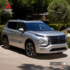 a silver suv parked in front of some bushes