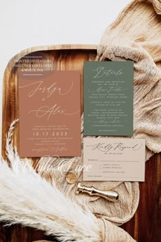 the wedding stationery is laid out on top of a wooden tray with furnishing