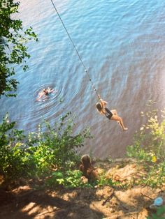 two people in the water on a rope that is connected to a body of water