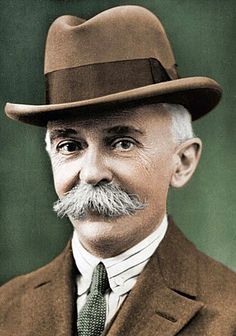 an old photo of a man wearing a hat and suit with a moustache