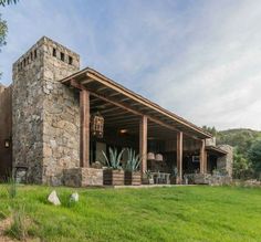 a stone building sitting on top of a lush green field