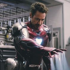 the iron man is looking at something in his hand