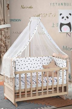 a baby's crib with a mosquito net over it and pillows on the floor