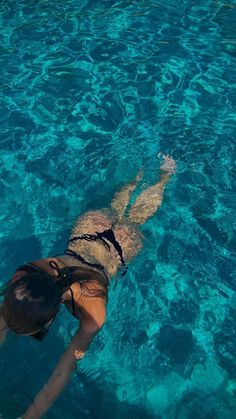 a woman is floating in the clear blue water