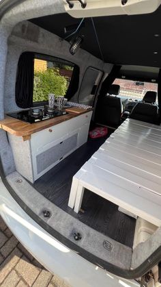 the back end of a van with two tables in it