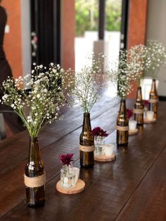 there are several vases with flowers in them on the table