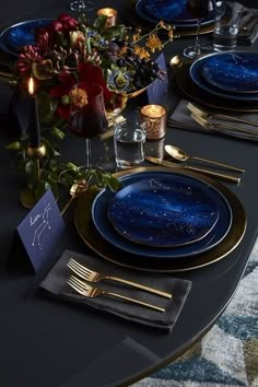 the table is set with blue and gold plates