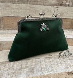 Stunning, handmade, green velvet purse bag with bee detail. The lining is made with a beautiful cotton fabric. Use it as a classic clutch or attach the shoulder strap to wear over your shoulder or as a crossbody - Silver colour Chain strap (detachable) - Silver colour Metal Top handle ( not detachable) - H:19cm x W:29cm x D:4cm approximately - Metal clasp: H:6.5cm x W:20cm - Top handle: H:8.5cm - Agate stone detail (The markings on the stone may be slightly different) The pattern of the lining i Green Clutch Bag As Gift, Green Clutch Bag For Gift, Green Clutch With Removable Pouch As Gift, Green Clutch With Removable Pouch For Gift, Velvet Pouch Bag For Gifts, Velvet Pouch Bag As Gift, Velvet Pouch Bag For Gift, Green Shoulder Evening Bag As Gift, Handmade Velvet Rectangular Bags