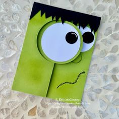 a close up of a paper cut out of a monster with big eyes and black hair