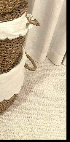 three wicker baskets stacked on top of each other in front of a white curtain