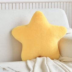 a yellow star pillow sitting on top of a white couch