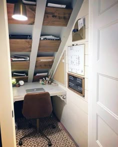 an office area with a desk and shelves on the wall, along with a chair