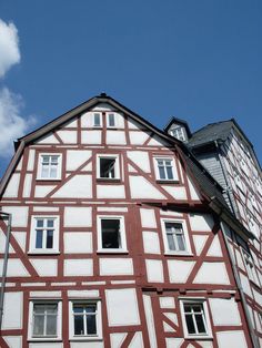 an old building with red and white paint on it's side, against a blue sky