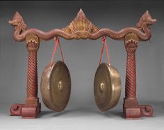 two gongs are sitting on top of each other in front of a metal frame