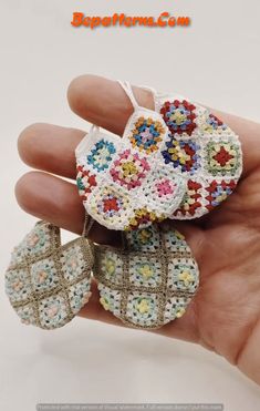 small crocheted earrings are being held in someone's hand