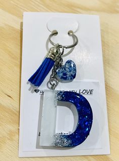 the letter d is made out of glass and has a tassel hanging from it