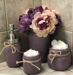 purple jars with soaps and flowers in them