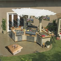 an outdoor kitchen and grill area in a backyard