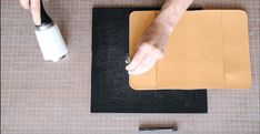 a person is using a tool to make a piece of leather