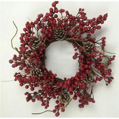 a wreath with red berries and pine cones on it is displayed against a white background