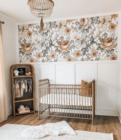 a baby's room with floral wallpaper and a crib