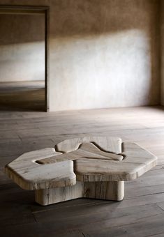 a wooden table sitting on top of a hard wood floor next to a mirror in an empty room