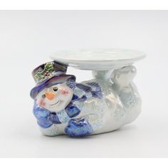 a glass figurine with a snowman holding a plate on it's back