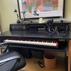 a black piano sitting on top of a hard wood floor next to a chair and lamp