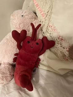 two stuffed animals laying next to each other on a bed