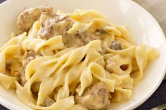 a white bowl filled with pasta and meatballs