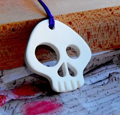 a white ceramic skull ornament hanging on a wall