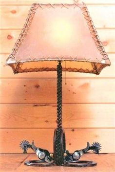 Western iron spur floor lamp with rawhide lamp shade. Made in the USA. Free shipping. Your Western Decor, LLC Western Lighting, Mountain Furniture, Western Lamps, Western Table, Lodge Lighting, Rustic Lamp Shades, Mountain Decor, Shoe Ideas, Iron Lamp