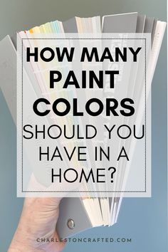 a hand holding a folder with the words how many paint colors should you have in a home?