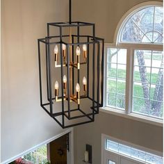 a chandelier hanging from the ceiling in a room with two windows and a door