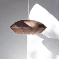 a light fixture hanging from a ceiling in a room with white walls and shadows on the wall