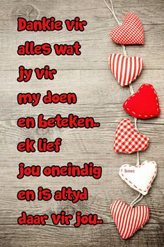 some hearts hanging from strings on a wooden surface with the words, dankie vir alles watt by vr my doen en belen